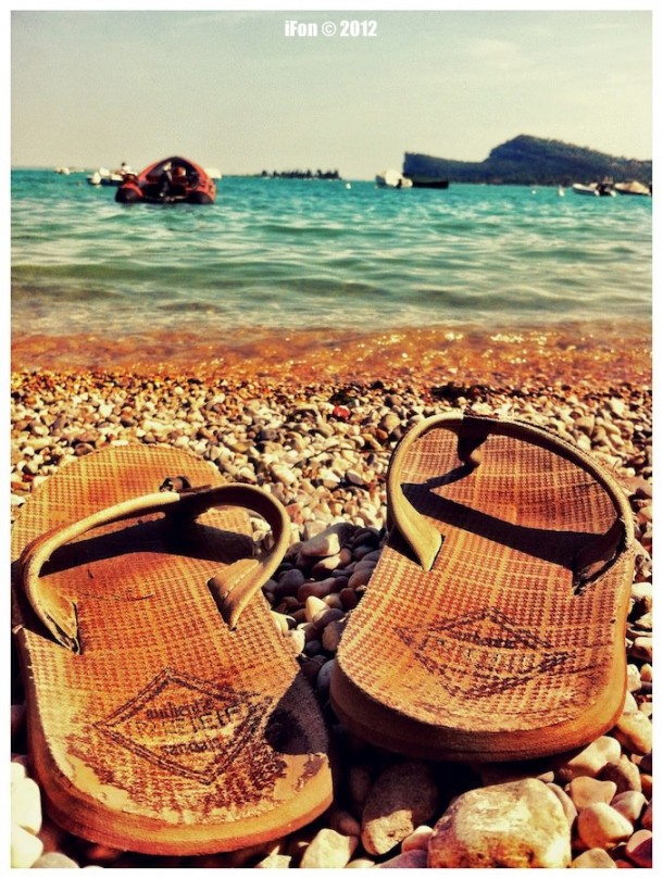 Strandschoenen op het strand aan het Gardameer